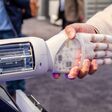 © Lukassek - stock.adobe.com Greifarm von Roboter oder Cobot schüttelt Hände mit Mensch
